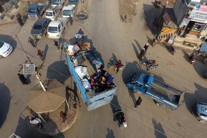 Syrian families flee the village of Hazano, about 20 kilometres northwest of the city of Idlib, towards the Turkish border on Sunday, after the regime stepped up advances against jihadists