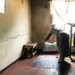 Where a child is born: Esther Gwena, 69, who acts as a midwife but has no training, lays down sheets in her rundown apartment -- a makeshift maternity unit
