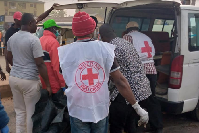 Victims being rescued by red cross men.  (Punch)