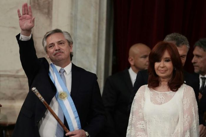 Argentina's new president, Alberto Fernandez, waves next to his vice-president Cristina Fernandez de Kirchner, after receiving the presidential sash from outgoing leader Mauricio Macri