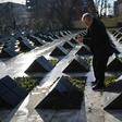 Ioan Banciu lights a candle next to the empty tomb of his wife, one of the victims of the Romanian revolution