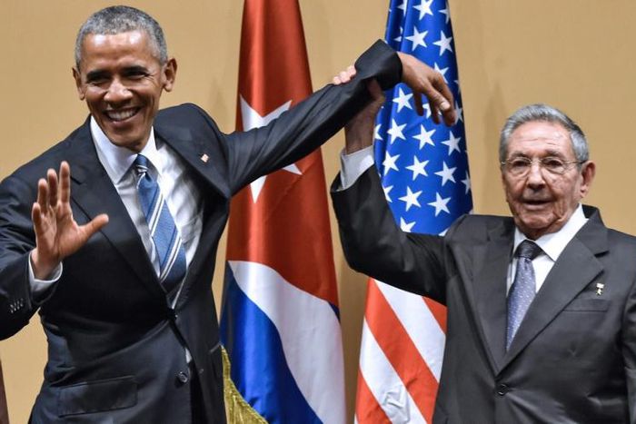 Cuban president Raul Castro raises US president Barack Obama's hand in Havana on March 21, 2016