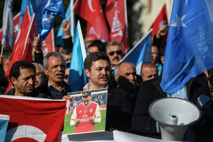 A supporter of China's Muslim Uighur minority holds a placard of Arsenal footballer Mesut Ozil during a demonstration in Istanbul