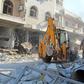 An excavator clears rubble following a reported  air strike in the Syrian town of Saraqib in Idlib province on Saturday