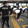 Physical trainer Javier Ramirez (C) works with police officers at a police unit in Mexico City