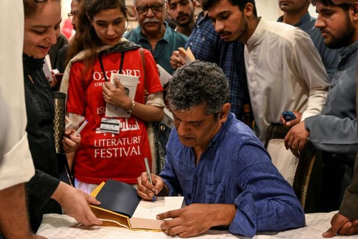Author Mohammed Hanif signing copies of his book "A Case of Exploding Mangoes" in Islamabad in September 2019 after the release of its Urdu translation

Featuring bumbling generals, assassination plots, and homosexual romance, Pakistani military satire...