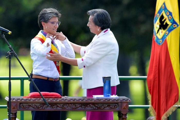 Bogota's incoming Mayor Claudia Lopez (L) is presented with the mayoral sash during her inauguration