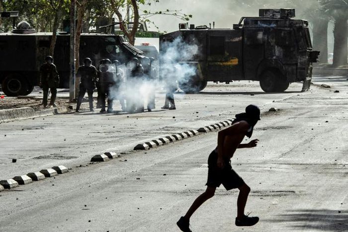 Demonstrators clash with riot police during a protest against President Sebastian Pinera's government in Santiago, on December 10
