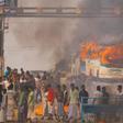 Protesters block a road after setting buses on fire during a demonstration against the Citizenship Amendment Bill in Howrah, on the outskirts of Kolkata