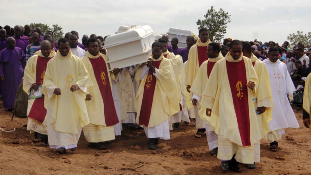 Clergymen carry white coffins containing the bodies of priests allegedly killed by Fulani herdsmen, for burial at Ayati-Ikpayongo in Gwer East district of Benue State, north-central Nigeria on May 22, 2018. [EMMY IBU / AFP via Getty Images]