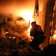 A volunteer firefighter battles a blaze after a night-time air strike on the Idlib province town of Ariha