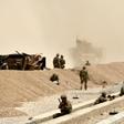 US soldiers are seen here keeping watch near the wreckage of their vehicle at the site of a Taliban suicide attack in Kandahar in 2017