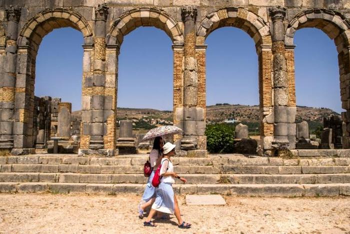 Tourists walk through the ruins of the ancient Roman site of Volubilis, near the Moroccan city of Meknes