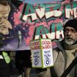 A protester holds a donation box for strikers in front of a banner portraying President Emmanuel Macron during a march against France's pension reform in Paris on Friday.