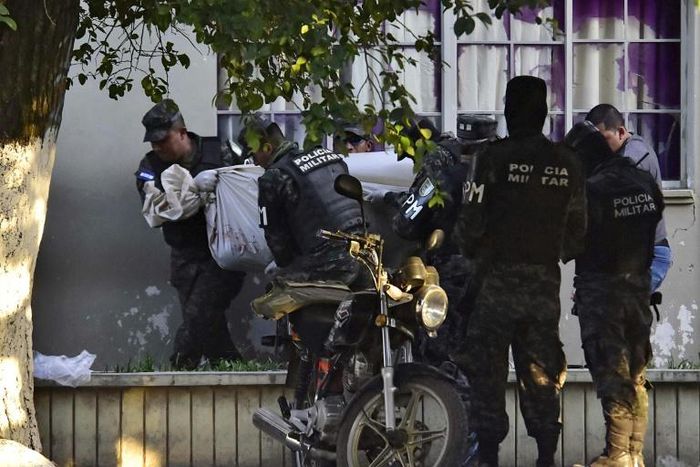 Honduran military police carry the body of a colleague after the escape of MS-13 gang leader Alexander Mendoza on February 13, 2020
