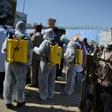 An Afghan policeman gestures as volunteers wearing a hazmat suits and a facemasks gather before the start of a preventive campaign against the spread of the COVID-19 coronavirus, in Kabul on March 18, 2020