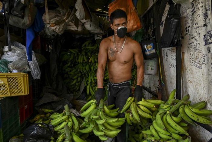 A man wears a face mask as he works at a market in Medellin, Colombia, on March 19, 2020