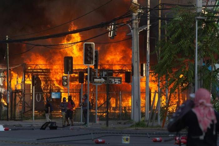Protesters set a construction site on fire  outside Santiago's Monumental stadium on January 29, 2020, after a fan of the Colo Colo team was run over by a police truck