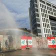 Lebanese anti-riot police fire tear gas and water cannons to try to prevent protesters scaling the blast walls around parliament
