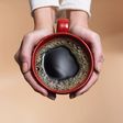 &quot;Woman holding coffee cup, close-up, overhead view&quot;