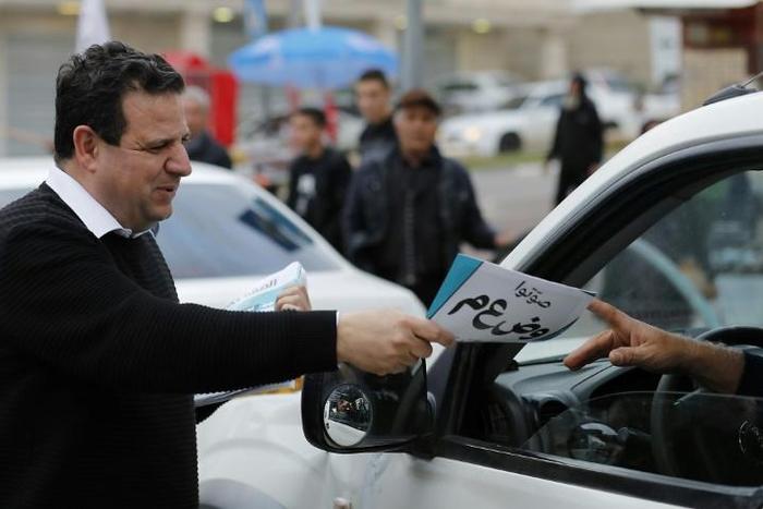 Leading Israeli Arab politician Ayman Odeh hands out leaflets while campaigning for Tuesday's general election