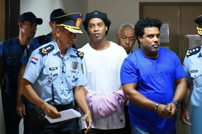 Brazilian football legend Ronaldinho (C) and his brother Roberto (R) arrive at Asuncion's Palace of Justice after being found using fake passports to enter the country