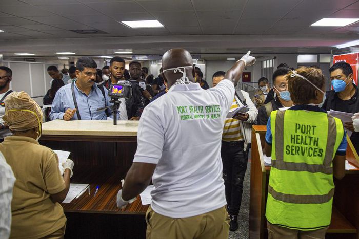 Nigerian official screening inbound passengers for Coronavirus at the airport. [Punch]
