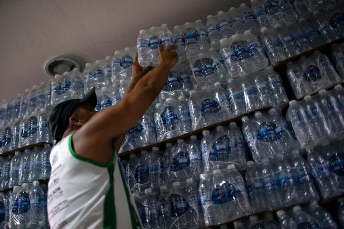 In this file photo taken on January 15, 2020, a man buys bottled water at a liquor store in the Lapa neighborhood of Rio de Janeiro