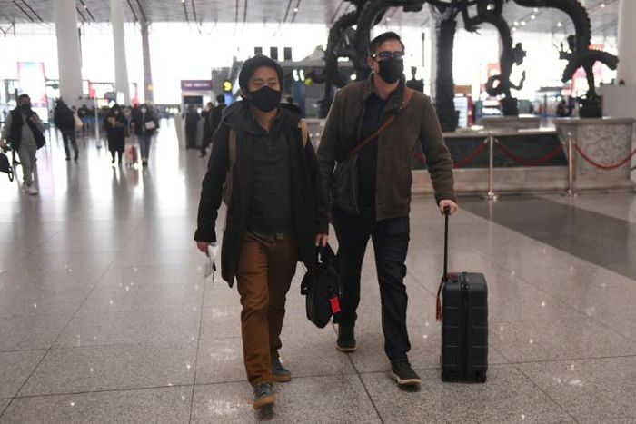 Wall Street Journal reporters Philip Wen (left) and Josh Chin walk through Beijing Capital Airport after being expelled by Chinese authorities