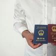 An unidentified Chinese Uighur man in the city of Medina holds his expired Chinese passport (red) and a one-way travel document (blue) issued in its place by the Chinese mission in Saudi Arabia