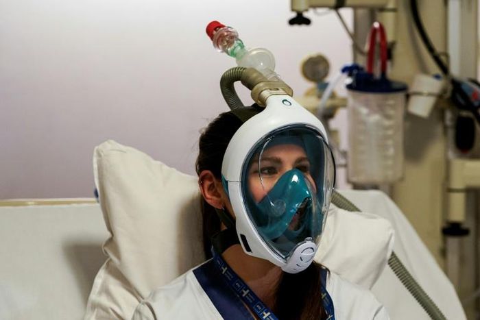 A medical worker tests a Decathlon snorkeling mask, with a 3D-printed respiratory valve fitting attached, at the Erasme Hospital in Brussels
