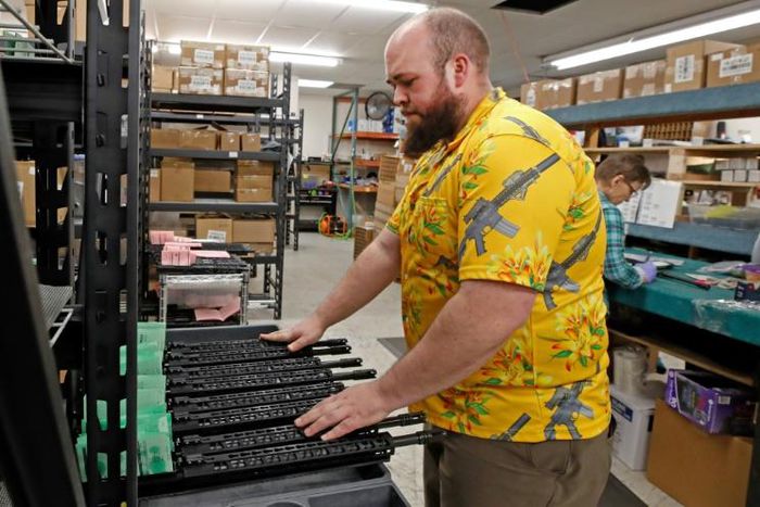 A worker moves finished AR-15 rifle barrels for storage at Delta Team Tactical in Orem, Utah