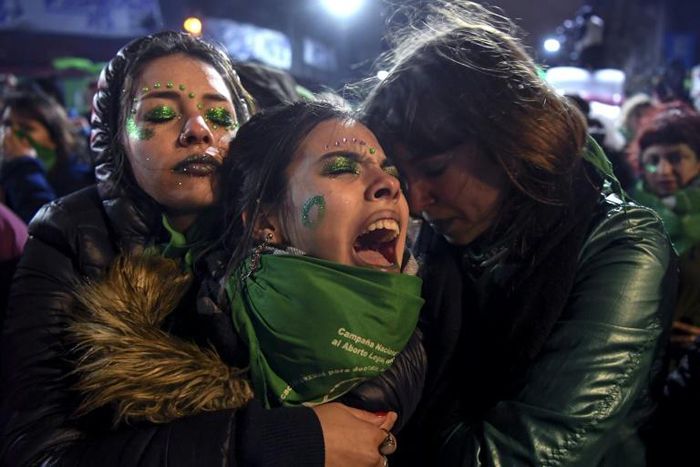 Activists in favor of abortion rights comfort each other outside the National Congress in Buenos Aires after senators rejected the bill to legalize the abortion in 2018