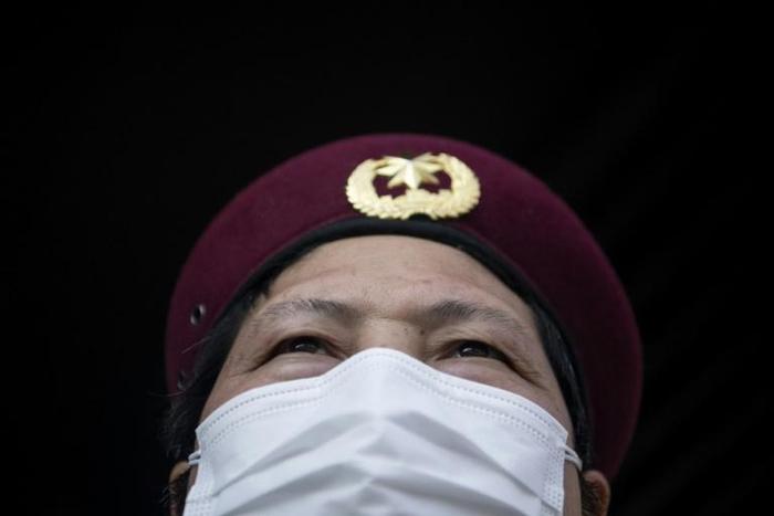 Security guards in Hangzhou take details from residents in order to enforce the limits on outbound trips