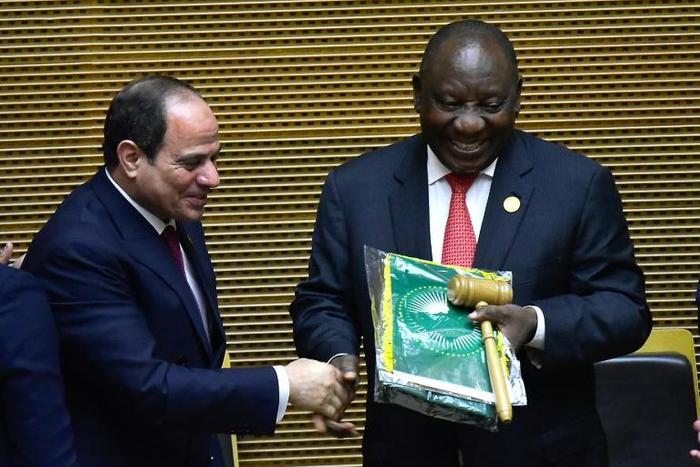 Handover: Outgoing AU chair Egyptian President Abdel Fattah al-Sisi, left, passes the baton to South African President Cyril Ramaphosa. Ramaphosa says settling the conflicts in Libya and South Sudan will be a priority of his tenure