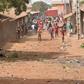 An anti-riot policeman faces young demonstrators in Conakry -- one of many protests that have unfurled over planned changes to the constitution