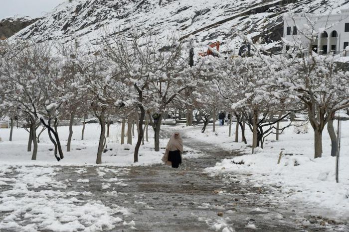 A woman walks down a path in Quetta, Pakistan, after heavy snow
