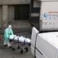 A health worker carries a body on a stretcher outside Gregorio Maranon hospital in Madrid