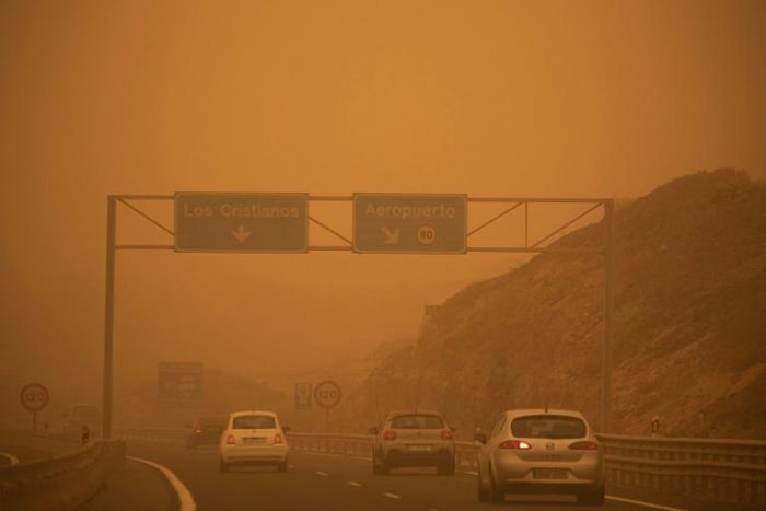 Cars drive on the TF-1 highway during a sandstorm in Santa Cruz de Tenerife, Spain, on February 23, 2020; airports on Spain's Canary Islands were closed after strong winds carrying red sand from the Sahara shrouded the tourist hotspot