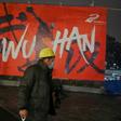 A man wearing a protective facemask walks along a street in Wuhan on January 26, 2020, a city at the epicentre of a viral outbreak that has killed at least 56 people and infected nearly 2,000