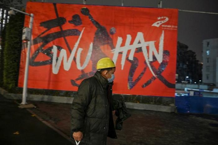 A man wearing a protective facemask walks along a street in Wuhan on January 26, 2020, a city at the epicentre of a viral outbreak that has killed at least 56 people and infected nearly 2,000