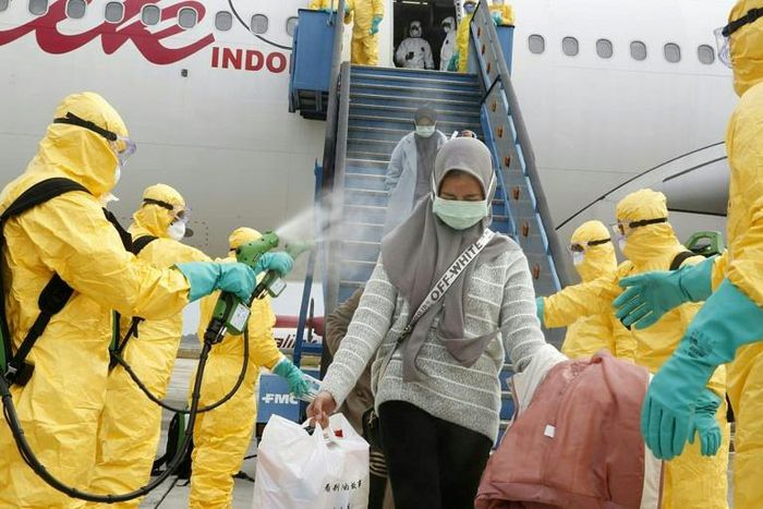 Health officials disinfect the evacuees from Wuhan, who will be quarantined on the island of Natuna for two weeks