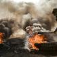 Anti-government protesters cut off a road with flaming tyres during a demonstration against Iraq's prime minister-designate Mohammad Allawi in the shrine city of Najaf, south of the capital