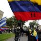 Protestors with their faces covered wave flags during a demonstration against the government of Colombia’s President Ivan Duque in Bogota