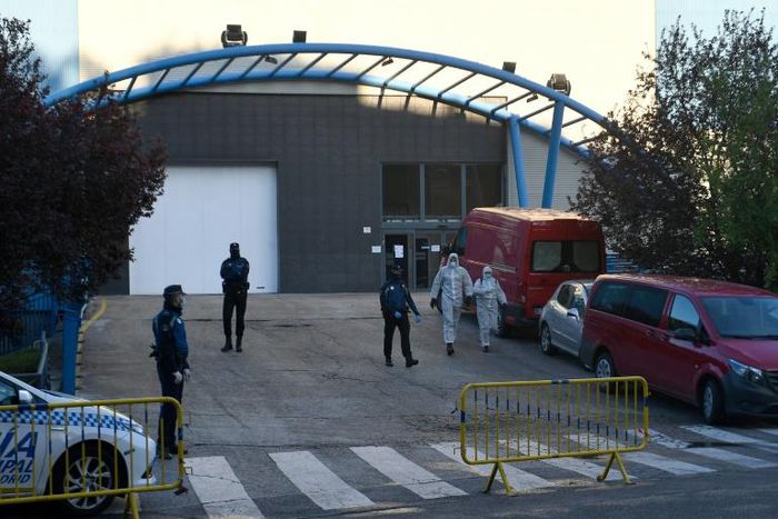 Policemen and undertakers wearing protective suits
stand outside the Palacio de Hielo (Ice Palace) in Madrid s