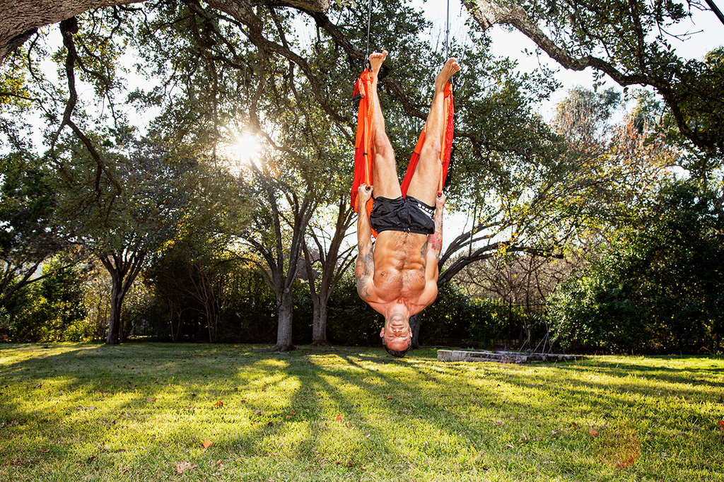 Aubrey Marcus doing acroyoga in his garden at his home in Austin, Texas.