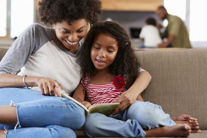 Mother and daughter reading a book [United Way]