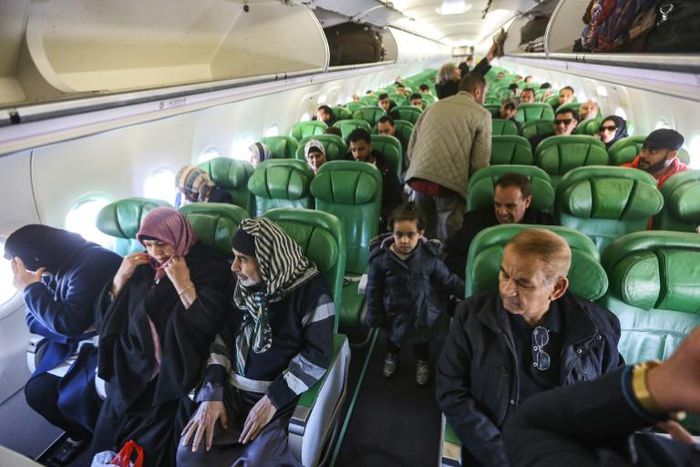 Passengers board and sit inside an aircraft at Mitiga airport, east of the Libyan capital Tripoli
