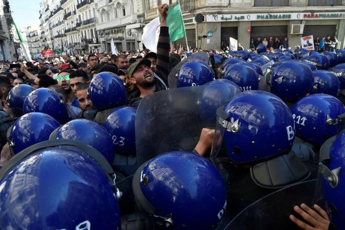 Algerian riot police block the progress of an anti-government demonstration heading towards the presidential palace in the capital Algiers, on Saturday