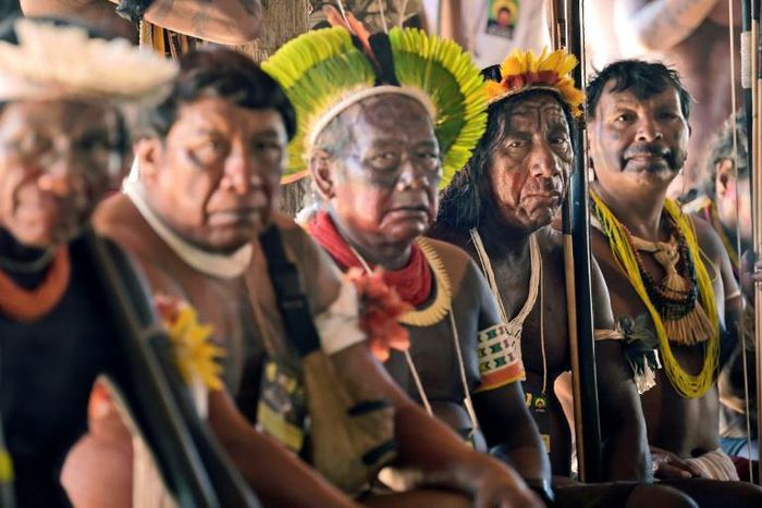 Indigenous tribesmen listen to Raoni chief Metuktire (out of frame) during a press conference in Piaracu village, near Sao Jose do Xingu, Mato Grosso state, Brazil